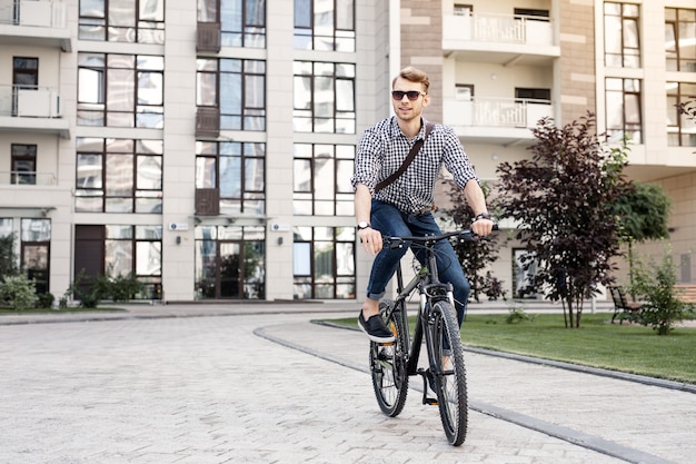 Vélo rapide. Homme heureux positif souriant tout en profitant de sa promenade sur le vélo