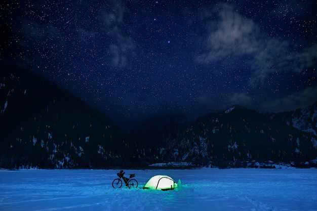 Vélo et tente au lac gelé la nuit