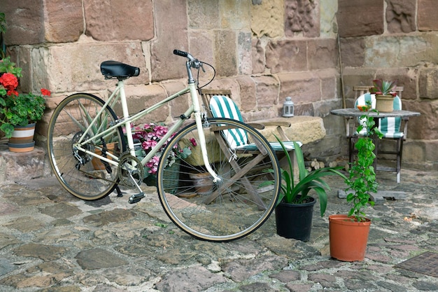 Vélo de tourisme classique garé dans une belle cour d'une maison rurale