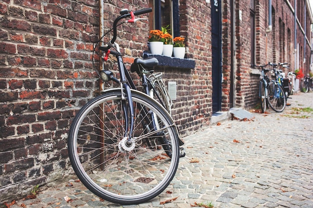 Vélo vintage en face du vieux mur de briques