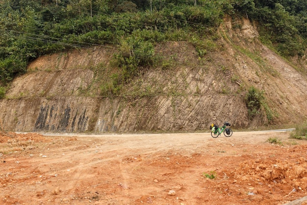 Vélo de voyageurs debout sur le bord de la route au Laos Montagne en arrière-plan