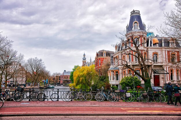 Des vélos au canal de la rivière Amstel et des bâtiments au remblai d'Amsterdam, Pays-Bas.