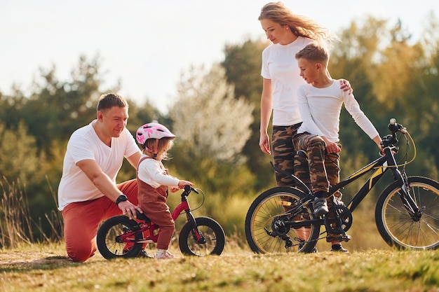 Avec des vélos Une famille heureuse passe le week-end ensemble à l'extérieur près de la forêt Avec sa fille et son fils