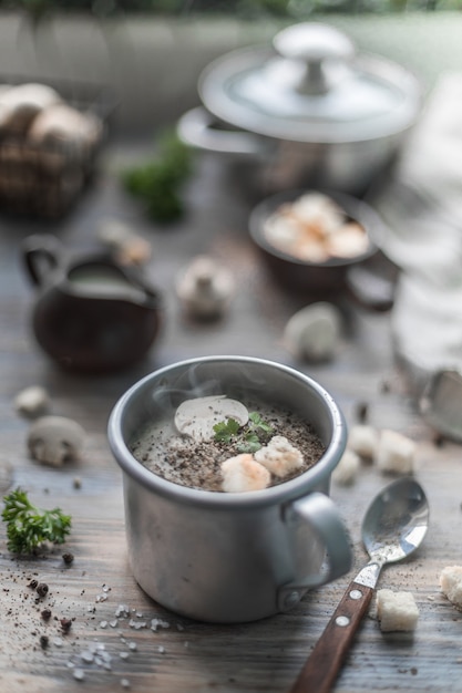 Velouté de champignons aux champignons avec de la vapeur dans une tasse en métal