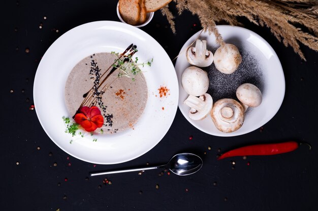 Velouté de champignons avec croûtons sur une surface sombre. vue de dessus