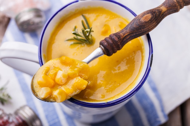 Velouté de maïs avec pâte de curry et romarin, dans un mug.