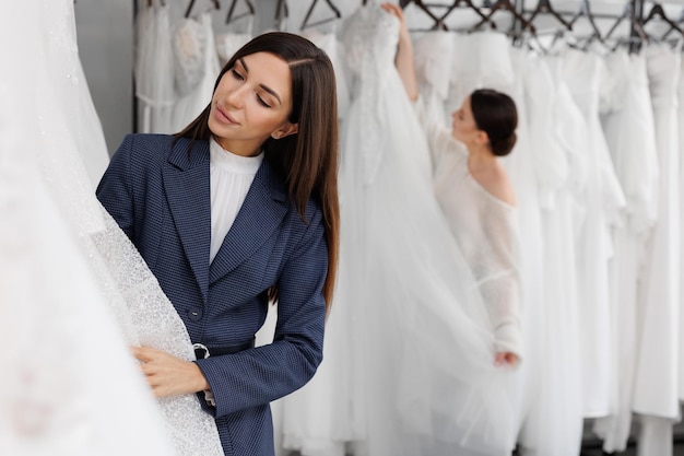 Le vendeur aidera la mariée à choisir sa robe de mariée.