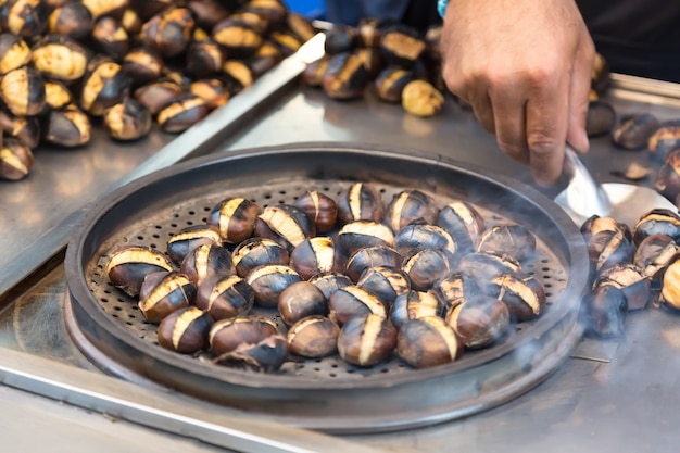 Un Vendeur Ambulant Vend Des Châtaignes Fraîchement Grillées à Istanbul, En Turquie.