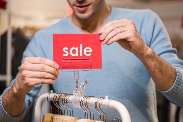 Le vendeur détient des panneaux rouges avec mot de vente