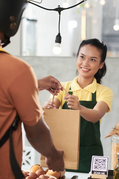 Vendeur donnant la commande au livreur