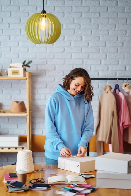 Vendeur entrepreneur propriétaire de petite entreprise à l'aide d'une tablette vérifiant les commandes de magasins de vêtements de commerce électronique