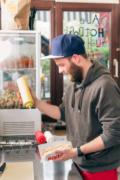 vendeur faisant hot-dog au fast food snack bar