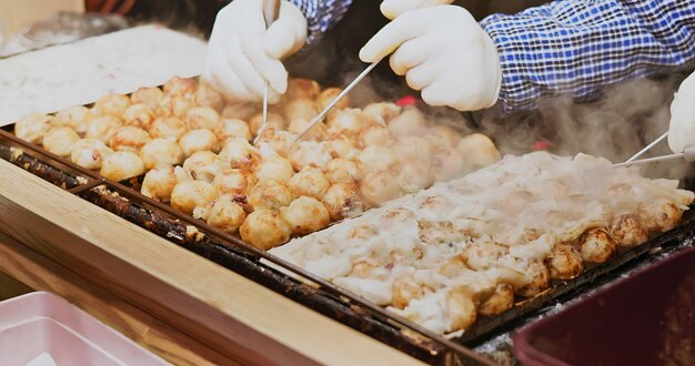 Photo le vendeur fait du takoyaki.