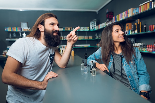 Photo vendeur fille montre le choix de la cigarette électronique.