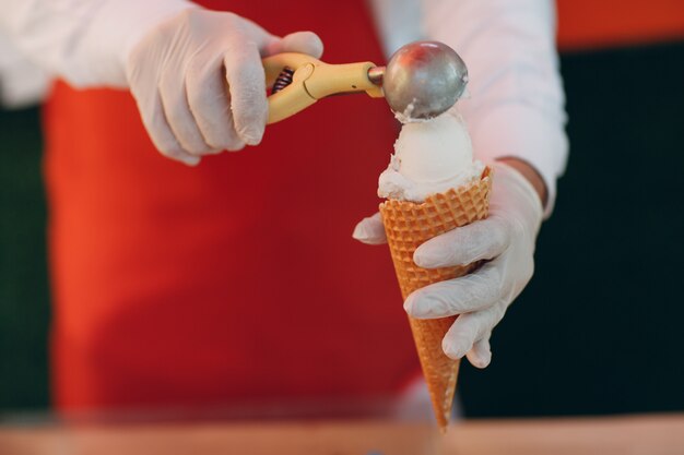 Le vendeur met de la glace dans un cornet gaufré