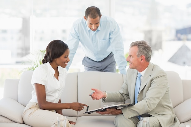 Vendeur montrant les clients où signer le contrat