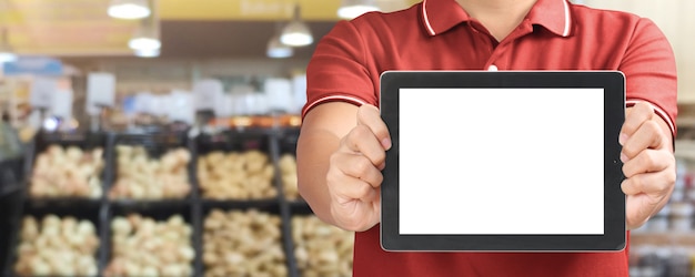 Vendeur montrant une tablette numérique vierge dans un supermarché Tablette dans un supermarché