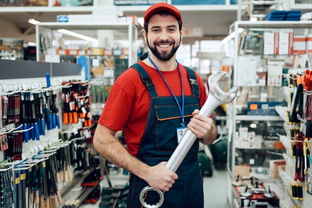 Vendeur pose avec une nouvelle clé géante en magasin.