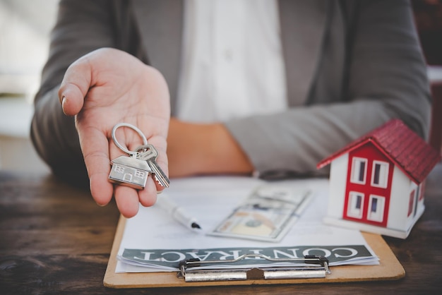 Vendeur tenant le concept des clés de la maison, clés de la maison pour la nouvelle maison, achat d'une nouvelle maison