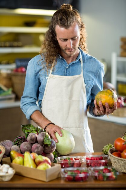 Vendeur tenant des fruits au comptoir