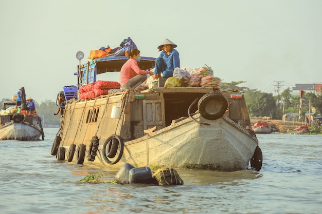 Vendeur vendant des légumes sur le marché flottant de Nga Nam dans le delta du Mékong au Vietnam.