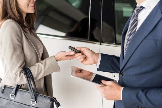 Vendeur de voitures donnant des clés au client