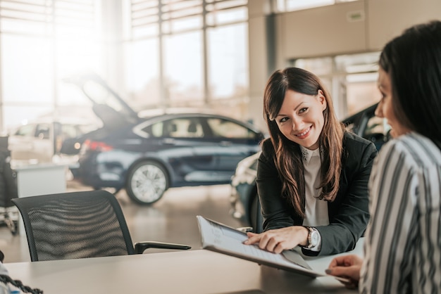 Vendeuse montrant le contrat au client.