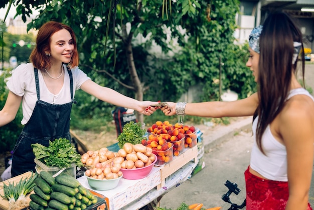 Une vendeuse propose un marché de producteurs de légumes frais et biologiques