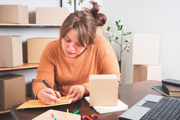 Vendre en ligneFemmes d'affaires qui travaillent à domicile et emballent en arrière-plan Achats en ligne des PME