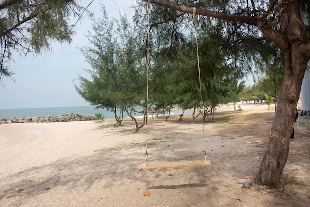 Vent et vague avec banc en bois balançoires jouet à l'heure du matin à la plage de Ban Pae à Rayong Thaïlande