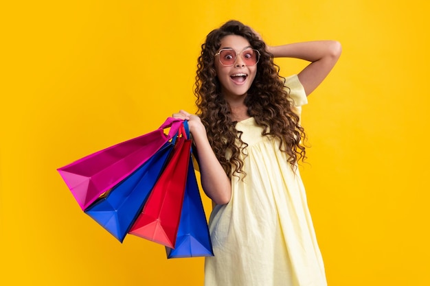 Vente d'achats d'été Adolescente étonnée élégante adolescente avec des sacs de vente pour enfants tenant des achats