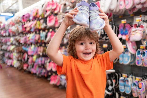 Vente consumérisme et concept de personnes Magasin de chaussures pour enfants dans un supermarché choisissant des enfants dans un magasin de chaussures Magasin de chaussures pour enfants