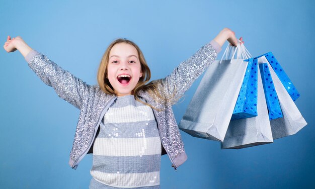 Vente saisonnière Cliente de la mode Fille heureuse dans la boutique avec des sacs Bonheur du jour du shopping Fille d'anniversaire shopping Boutique de mode Tendance de la mode Boutique de mode Petite fille avec des paquets de tas