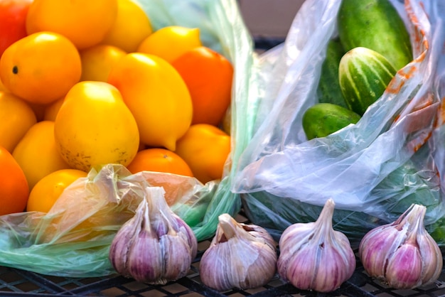 Vente de tomates mûres et d'ail dans un bazar de rue Légumes mûrs frais cultivés dans une ferme sur un petit comptoir