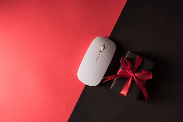 Vente de vendredi noir shopping de boîte-cadeau enveloppé dans du papier noir et ruban arc rouge et souris d'ordinateur
