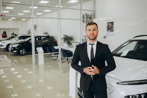Vente de voitures d'affaires technologie et concept de personnes couple heureux avec un concessionnaire de voitures dans un salon d'automobiles ou un salon
