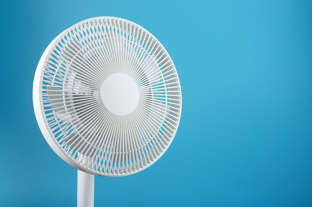 Ventilateur électrique en blanc avec un design moderne pour rafraîchir la pièce sur fond bleu