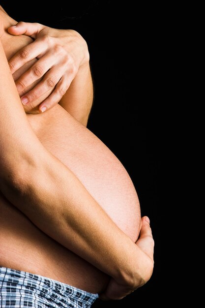 Photo ventre de femme enceinte sur fond noir