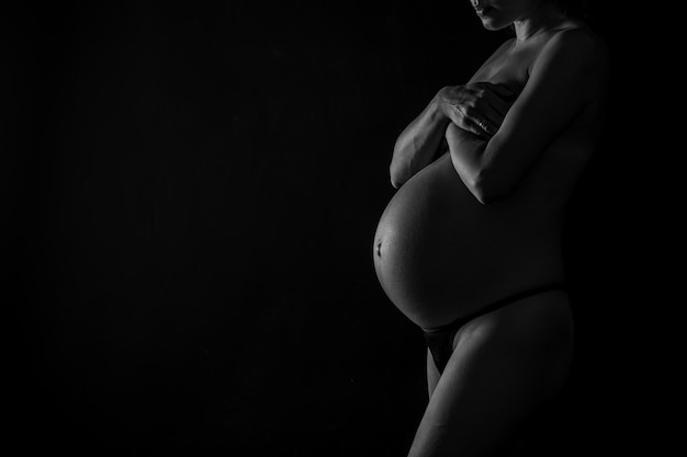 Ventre d'une fille enceinte gros plan et mains sur le ventre d'une fille enceinte