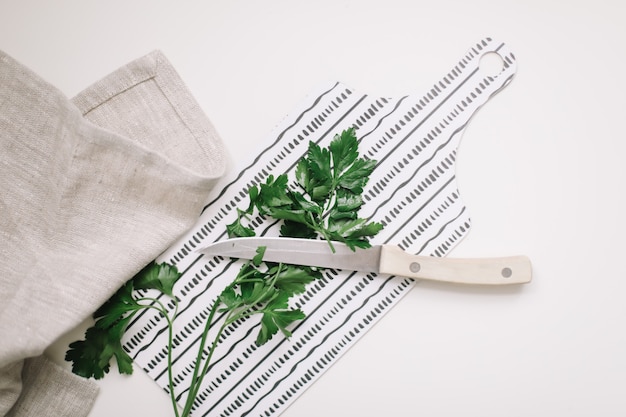 verdure de persil frais avec couteau et torchon sur planche à découper vue de dessus