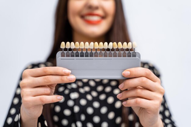 Vérifiez et sélectionnez la couleur des dents dans le cabinet du dentiste Processus de choix de la couleur des dents pour une belle jeune fille