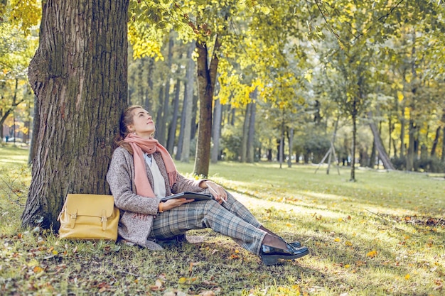 Véritable femme d'affaires avec ordinateur portable tablette au travail à l'extérieur dans le parc