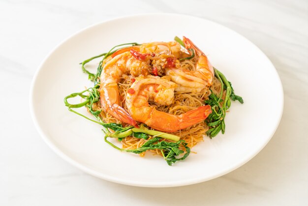 Vermicelles de riz sautés et mimosa d'eau aux crevettes sur assiette