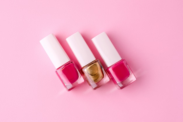 Vernis à ongles cosmétiques rose et or sur rose