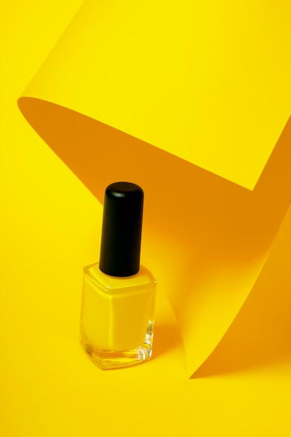 Vernis à ongles jaune isolé sur fond jaune Concept esthétique