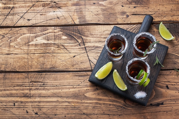 Verre avec de l'alcool, du sel et du citron vert sur un bois