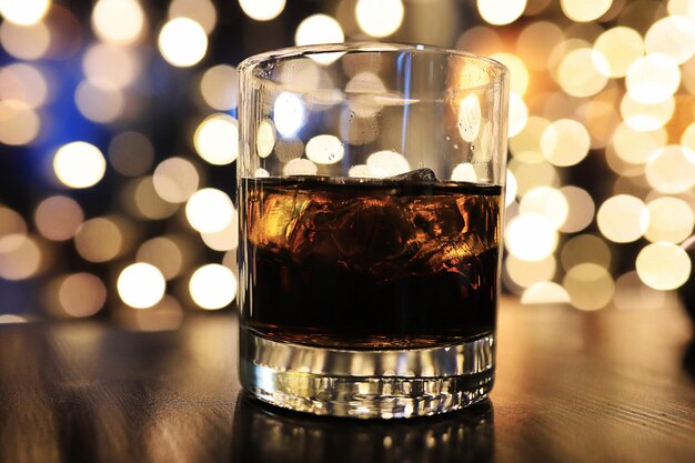 Verre d'alcool avec de la glace sur fond blured avec cercle bokeh