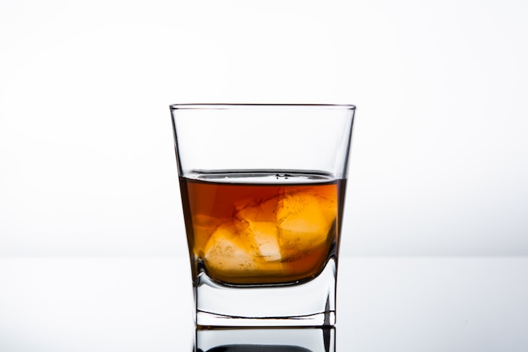 Photo verre d'alcool sur un mur blanc