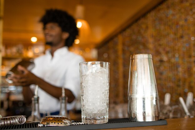 Un verre avec un barman derrière.