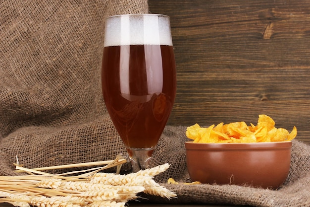 Verre de bière avec assiette de frites sur table en bois sur fond de limogeage